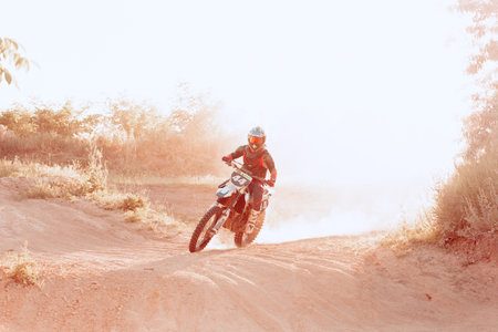 Professional motorcycle rider training on Enduro motorcycle at steppe or desert area, outdoors at...