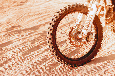 Close up motorcycle wheel on dust road, sand. Details. Motocross sport concept