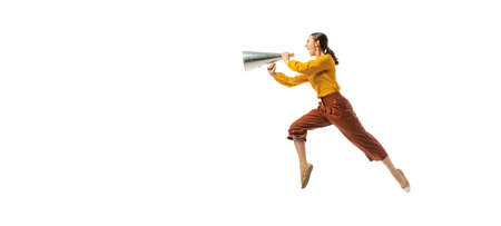 Flyer with expressive young girl shouting at megaphone isolated on white background. News, start-up, open-space, professional occupation concept.の写真素材