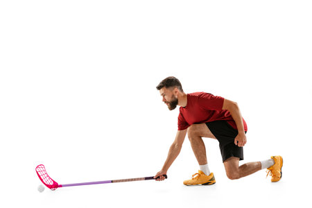 Dynamic portrait of male floorball player with floorball stick in action isolated on white background. Sport, competition and motion, movement, active lifestyleの写真素材