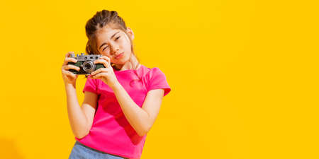 Emotional little girl, kid in casual style clothes isolated over bright yellow background. Concept of children emotions, fashion, beauty, school and ad, retro styleの写真素材
