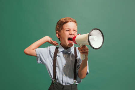 One preschool boy, kid wearing retro style outfit isolated on dark green background. Concept of...
