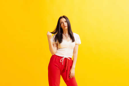 Studio shot of young beautiful woman in summer casual style outfit isolated on bright yellow background. Concept of beauty, art, fashion, human emotionsの写真素材