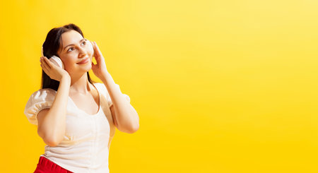 Studio shot of young beautiful woman in summer casual style outfit isolated on bright yellow background. Concept of beauty, art, fashion, human emotionsの写真素材