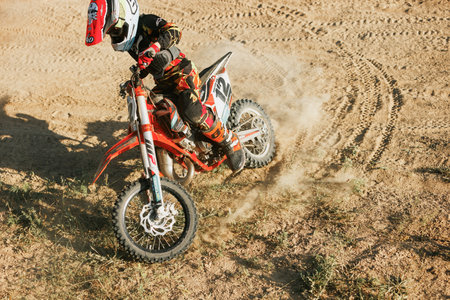 Dnipro, Ukraine JULY 01, 2022. Ukrainian beginner motorcycle rider driving on Enduro motorbike, outdoors at hot summer day. Kids motocross trainingのeditorial素材