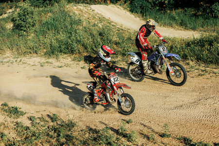 Dnipro, Ukraine JULY 01, 2022. Ukrainian beginner motorcycle rider driving on Enduro motorbike, outdoors at hot summer day. Kids motocross trainingのeditorial素材