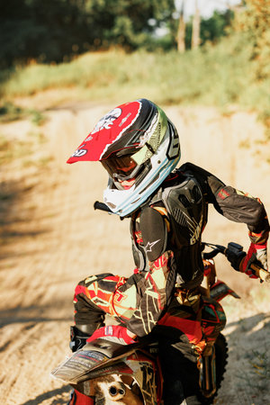 Dnipro, Ukraine JULY 01, 2022. Ukrainian beginner motorcycle rider driving on Enduro motorbike, outdoors at hot summer day. Kids motocross trainingのeditorial素材