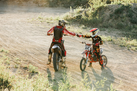 Dnipro, Ukraine JULY 01, 2022. Ukrainian beginner motorcycle rider driving on Enduro motorbike, outdoors at hot summer day. Kids motocross training