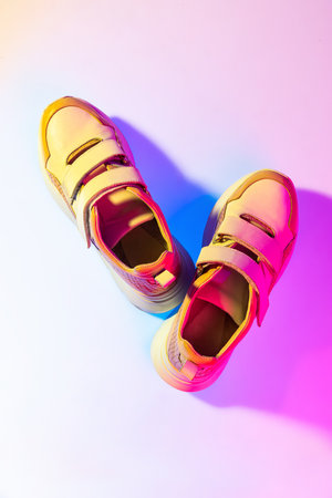 Aerial view of sports shoes, sneakers isolated over neoned background. Urban city fashion, fitness, sport, training concept.の写真素材