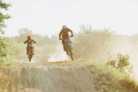 Professional and junior sportsmen, motorcyclist training on motorbike at hot summer day, outdoors....