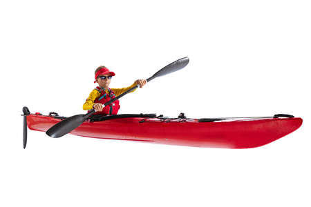 Beginner kayaker in red canoe, kayak with a life vest and a paddle isolated on white background. Concept of sport, nature, travel, active lifestyleの写真素材