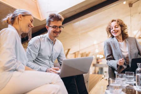 Project team. Group of happy, motivated young people discussing plans and projects. Coworkers working at office, indoors. Concept of businessの写真素材