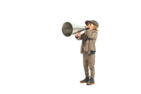 Charming little kid shouting through vintage megaphone. Communication concept. Retro style. Beauty, kids fashion, education, happy childhoodの写真素材