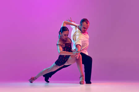Feelings in dance. Emotional dancers dancing ballroom dance isolated on purple background. Concept of art, beauty, music, style.の写真素材