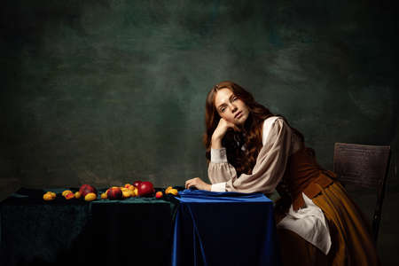 Vintage style. Young charming redhair girl with long curly hair like girl of renaissance eras...