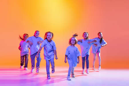 Group of children, little girls in sportive casual style clothes dancing in choreography class...