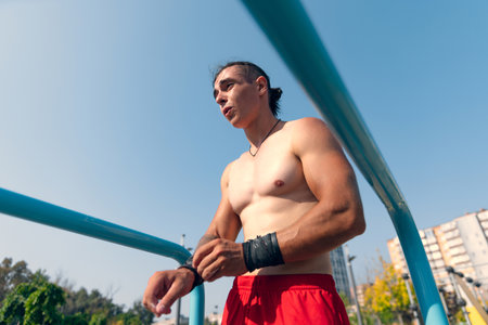Handsome young muscular man in red shorts at sports ground at public park in summer morning. Sport, fitness, healthy lifestyle conceptの写真素材