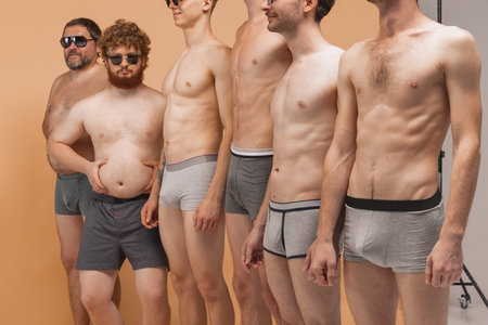 Silly photoshoot. Six men of different ages and body shapes take part at photo shoot in underwear at...