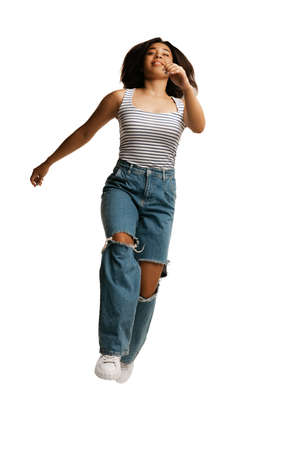 Cheerful young girl, student running isolated on white background. Concept of beauty, art, fashion,...