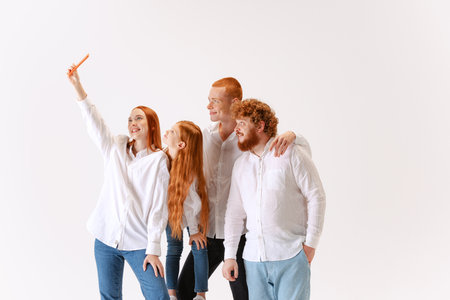 Selfie for memory. Cheerful young red-haired people, friendly family wearing white shirts and jeans...
