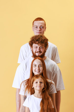 Merry red-haired youth, smiling boys and girls looking at camera over yellow background. Funny staircase. Diversity conceptの写真素材