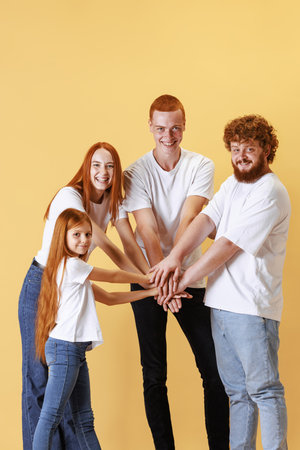 Care and support. Group of different ages redhead people holding their hands and laughing isolated...