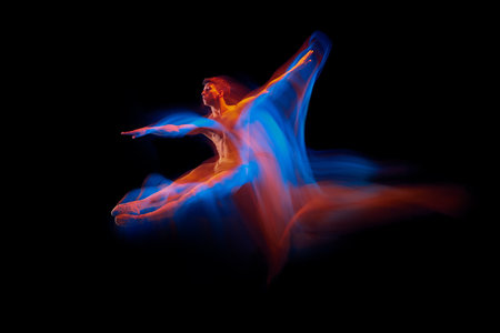 Aspiration. Solo performance of flexible male ballet dancer dancing isolated on dark background in glowing colorful neon light. Grace, art, beautyの写真素材