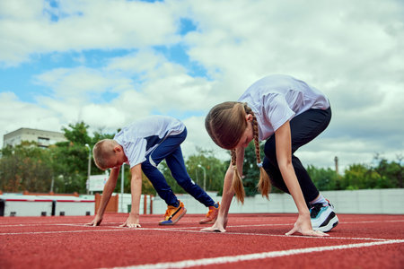 Start. Group of kids getting ready to run on treadmill at the stadium or arena. Little boys, girls in sportswear training as athletes outdoor. Concept of sport, achievements, studying, skillsの写真素材