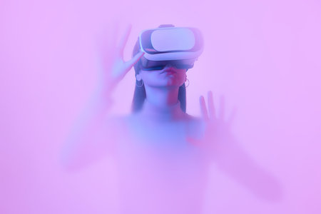 Virtual reality. Young girl in VR eyewear, immersed in clouds of smoke, fog on a pink neon...