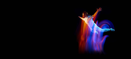Dance in motion. Studio shot of flying, jumping dancer or gymnast performing tricks in the air over...