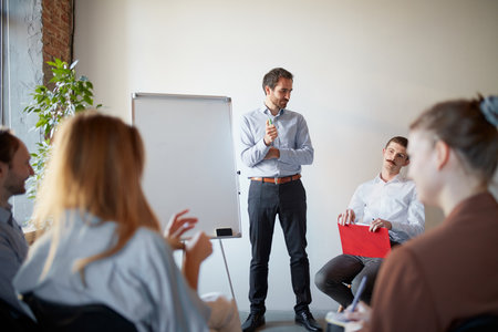 Young people talking, working, discussing problems and ideas with colleagues, co-workers at office meeting room. Professional occupation, career, motivationの写真素材