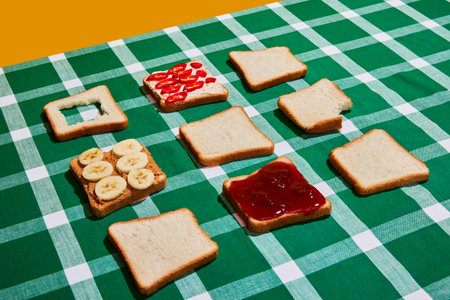 Creative composition with different toasts on plaid green and white tablecloth background. Vintage, retro style. Food pop art photography.の写真素材