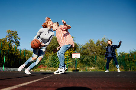 Group of teens, students playing street basketball at basketball court outdoors. Sport, leisure activities, hobbies, team, friendshipの写真素材