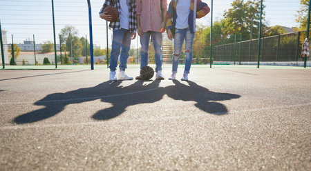 Young boys and girls, students bonding outdoors to play street basketball. Teens wearing casual style clothes. Youth, sport, energy, motion, active lifestyleの写真素材