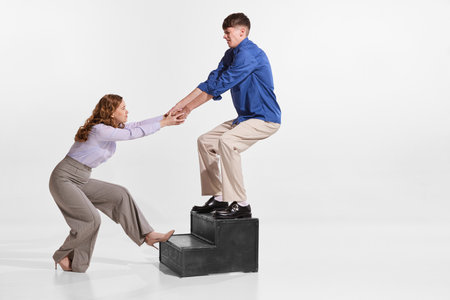 Portrait of man and woman, employees helping each other in professional sphere isolated over white...