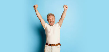 Portrait of mature man in white T-shirt posing isolated over blue studio background. Winning look. Successの写真素材