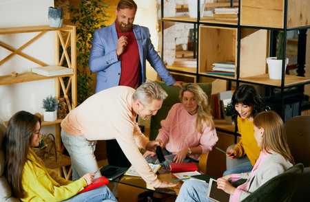 Group of employees, men and women, having meeting, creative discussion of projects at the office, indoors. Concept of business, brainstorming, conferenceの写真素材