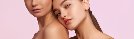 Wellness. Cropped portrait of two young, beautiful girls with perfect skin isolated over pink studio background. Concept of skincare, cosmetology, natural beautyの写真素材