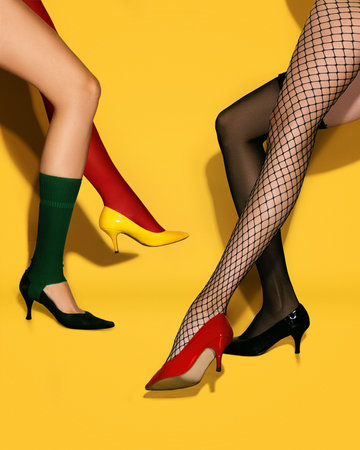 Contemporary art collage. Creative colorful design. Female slim legs in different heeled shoes over...