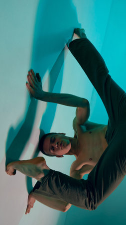 Contemporary dance style. Upside down. Young shirtless man dancing contemp, experimental dance over...