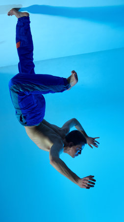 Contemporary dance style. Upside down. Young artistic man dancing contemp, experimental dance over...