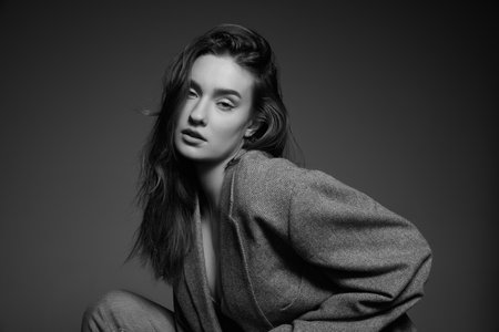 Black and white photography. Portrait of young beautiful girl with nude makeup posing in stylish...