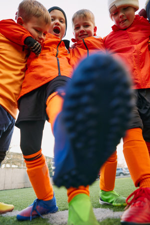 Positive emotions. Group of little boys, children in uniform, football players on outdoor playground. Concept of sport, childhood, active lifestyleの写真素材