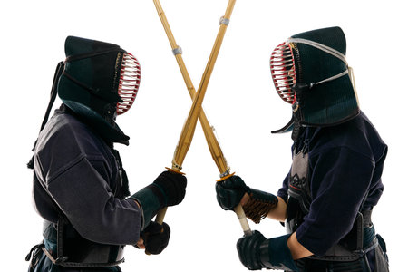 Two men, professional kendo fighter, athletes in black uniform training, crossing swords against...