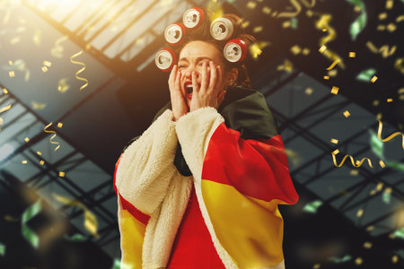 Losing game. Young woman, football fan with german flag covering face with hands. Unsuccessful game and championshipの写真素材