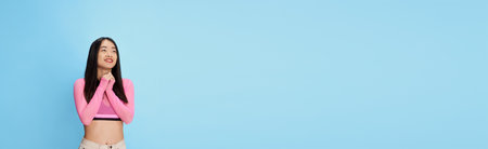 Surprise. Portrait of young beautiful girl posing with excited emotion face against blue studio background. Concept of emotions. Bannerの写真素材