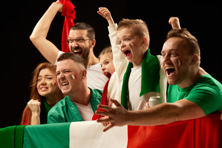 Excited people standing with flag of country. Football, soccer fans emotionally cheering up favourite team during match. Men visiting game with kidsの写真素材