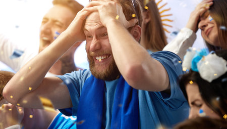 Failure. Losing game. Sad men, sport fans emotionally watching football match of greece soccer team at stadiumの写真素材