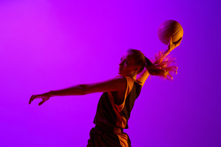 Throwing ball into basket. Female basketball player, young girl in motion, training, playing against white studio background. Concept of professional sportの写真素材