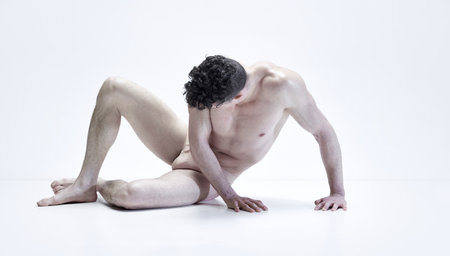 Masculinity. Muscular shirtless man posing in beige underwear against white studio background. Relief body shapeの写真素材